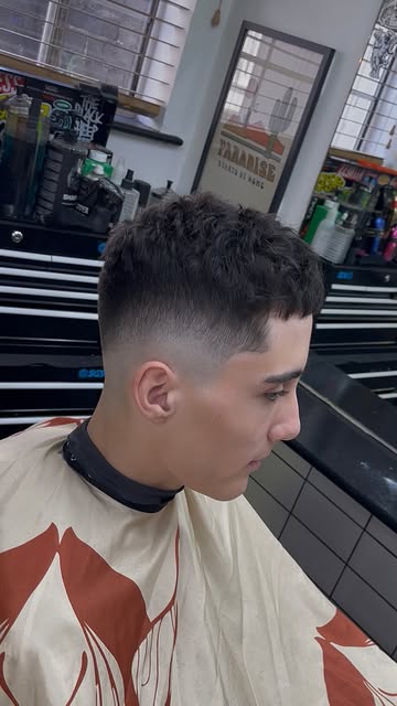 A curly crop with a skin fade, side profile